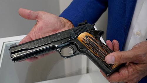 Close-up of Brian Witherell's hands holding Al Capone's 'favorite' pistol.